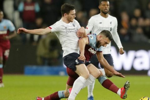 Liverpool's Andrew Robertson, front left, duels for the ball with West Ham's Robert Snodgrass during the English Premier League soccer match between West Ham Utd and Liverpool at the London Stadium in London, Wednesday, Jan. 29, 2020. (AP Photo/Frank Augstein)
