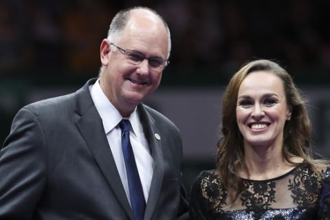 Martina Hingis of Switzerland, is presented with a gift by WTA Chief Executive Officer Steve Simon during her retirement ceremony at the WTA tennis tournament in Singapore, on Sunday, Oct. 29, 2017. (AP Photo/Yong Teck Lim)