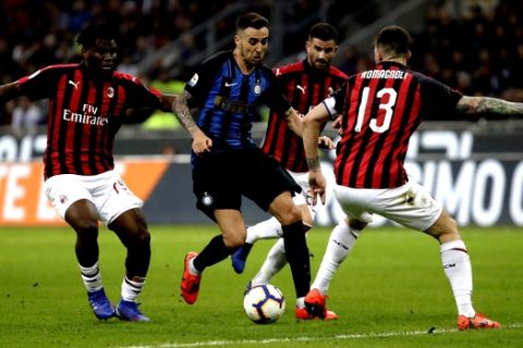 Inter Milan's Matias Vecino, second left, runs with the ball between AC Milan's Franck Kessie, left, AC Milan's Alessio Romagnoli, right, and AC Milan's Mateo Musacchio during a Serie A soccer match between AC Milan and Inter Milan, at the San Siro stadium in Milan, Italy, Sunday, March 17, 2019. (AP Photo/Luca Bruno)