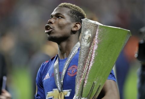 Manchester's Paul Pogba holds the trophy after winning 2-0 during the soccer Europa League final between Ajax Amsterdam and Manchester United at the Friends Arena in Stockholm, Sweden, Wednesday, May 24, 2017. (AP Photo/Michael Sohn)