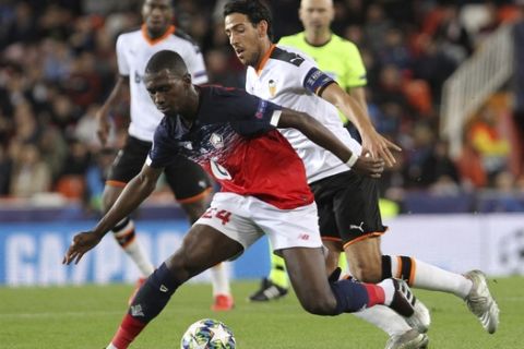 Lille's Boubakary Soumare, front, vies for the ball with Valencia's Dani Parejo during the Champions League group H soccer match between Valencia and Lille at the Mestalla stadium in Valencia, Spain, Tuesday, Nov. 5, 2019. (AP Photo/Alberto Saiz)