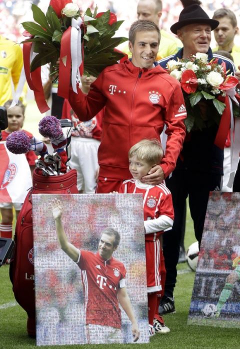 Bayern's Philipp Lahm stands besides his son Julian during his farewell celebration prior to the German first division Bundesliga soccer match between FC Bayern Munich and SC Freiburg at the Allianz Arena stadium in Munich, Germany, Saturday, May 20, 2017. (AP Photo/Matthias Schrader)