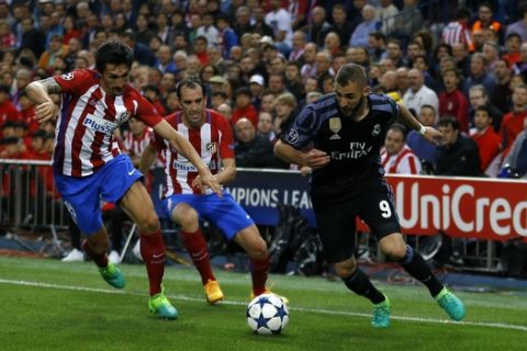 Real Madrid's Karim Benzema, right, controls the ball as Atletico Madrid's Stefan Savic, left, and Diego Godin try to stop him during the Champions League semifinal second leg soccer match between Atletico Madrid and Real Madrid at the Vicente Calderon stadium in Madrid, Wednesday, May 10, 2017. (AP Photo/Francisco Seco)