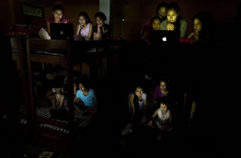 Indian children at a school hostel watch on laptops the World Cup soccer final match between France and Croatia on the outskirts of Gauhati, India, Sunday, July 15, 2018. (AP Photo/Anupam Nath)