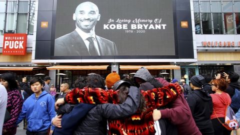 Fans of Kobe Bryant mourn in front of his image at the LALive area across from Staples Center, home of the Los Angeles Lakers, after word of the Lakers star's death in a helicopter crash, in downtown Los Angeles Sunday, Jan. 26, 2020. (AP Photo/Matt Hartman)