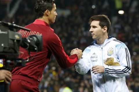 Lionel Messi of Argentina, right, greets Cristiano Ronaldo of Portugal before their International Friendly soccer match at Old Trafford Stadium, Manchester, England, Tuesday Nov. 18, 2014. (AP Photo/Jon Super)  