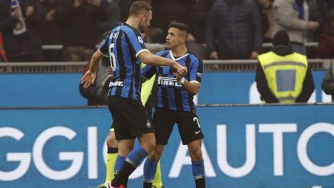 Inter Milan's Stefan de Vrij, left, celebrates with Inter Milan's Alexis Sanchez after his scored his side's third goal during the Serie A soccer match between Inter Milan and AC Milan at the San Siro Stadium, in Milan, Italy, Sunday, Feb. 9, 2020. (AP Photo/Antonio Calanni)