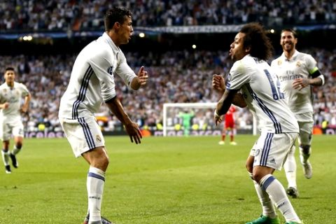 Real Madrid's Cristiano Ronaldo, left, celebrates with Marcelo after scoring his side's third goal during the Champions League quarterfinal second leg soccer match between Real Madrid and Bayern Munich at Santiago Bernabeu stadium in Madrid, Spain, Tuesday April 18, 2017. (AP Photo/Daniel Ochoa de Olza)