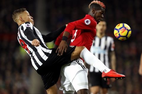 Newcastle United's Dwight Gayle, left, and Manchester United's Paul Pogba battle for the ball during their English Premier League soccer match at Old Trafford, Manchester, England, Saturday, Nov. 18, 2017. (Martin Rickett/PA via AP)