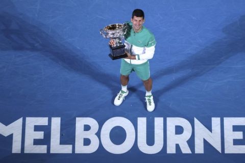 Ο Νόβακ Τζόκοβιτς ποζάρει κρατώντας στα χέρια του το τρόπαιο του Australian Open