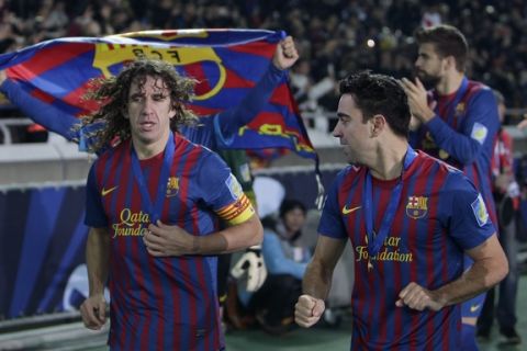 Spain's FC Barcelona defender Carles Puyol, left, and midfielder Xavi Hernandez celebrate during a victory run after their 4-0 win over Brazil's Santos FC in their final match at the Club World Cup soccer tournament in Yokohama, near Tokyo, Japan, Sunday, Dec. 18, 2011. (AP Photo/Shizuo Kambayashi)