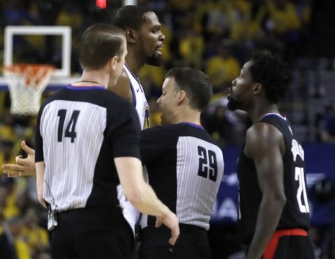 Umpire Mark Lindsay (29) and crew chief Ed Malloy (14) separate Golden State Warriors' Kevin Durant and Los Angeles Clippers' Patrick Beverley, right, during the second half in Game 1 of a first-round NBA basketball playoff series Saturday, April 13, 2019, in Oakland, Calif. Durant and Beverley were ejected. (AP Photo/Ben Margot)