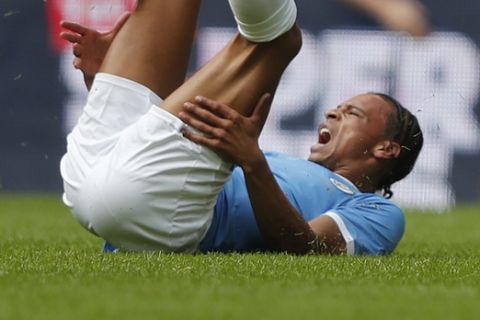 Manchester City's Leroy Sane lies injured on the ground after a collision with Liverpool's Trent Alexander-Arnold during the Community Shield soccer match between Manchester City and Liverpool at Wembley Stadium in London, Sunday, Aug. 4, 2019. (AP Photo/Frank Augstein)