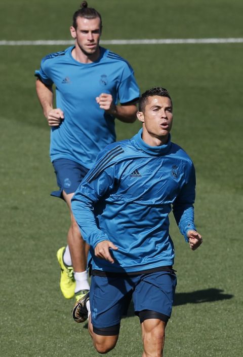 Real Madrid's Cristiano Ronaldo runs ahead of Gareth Bale during a training session in Madrid, Spain, Tuesday, Sept. 12, 2017. Real Madrid will play APOEL Nikosia Wednesday in a Group H Champions League soccer match. (AP Photo/Paul White)