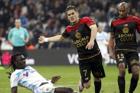 Marseille's forward Bafetimbi Gomis, left, challenges for the ball with Guingamp's defender Dorian Leveque, center, and defender Jeremy Sorbon, during the League One soccer match between Marseille and Guingamp, at the Velodrome Stadium, in Marseille, southern France, Wednesday, Feb. 8, 2017. (AP Photo/Claude Paris)
