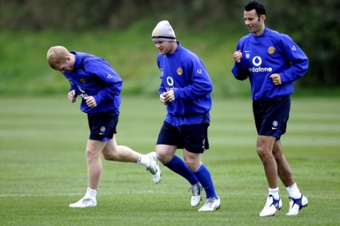 Manchester United's Wayne Rooney, centre, Paul Scholes, left, and Ryan Giggs warm up as the side is put through its paces at Carrington training ground the day before their Champions League tie against Benfica of Portugal, Manchester, England, Monday, Sept. 26, 2005. (AP Photo/Jon Super)  

