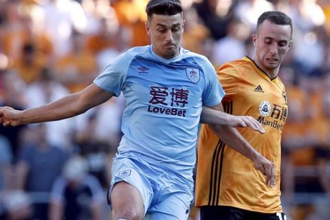Wolverhampton Wanderers's Diogo Jota, right, and Burnley's Matthew Lowton battle for the ball during the English Premier League soccer match Between Burnley and Wolverhampton Wanderers at Molineux, Wolverhampton, England, Sunday Aug. 25, 2019. (Darren Staples/PA via AP)