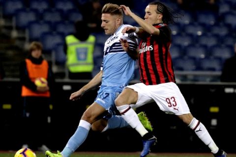 Lazio's Ciro Immobile, left, challenges for the ball with AC Milan's Diego Laxalt during the Italian Cup, first leg semifinal soccer match between Lazio and AC Milan at the Olympic stadium in Rome, Italy, Tuesday, Feb.26, 2019. (AP Photo/Gregorio Borgia)