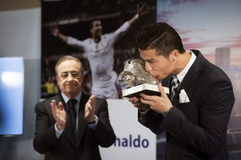 epa04960318 Portuguese forward of Real Madrid Cristiano Ronaldo kisses his trophy in presence of President of Real Madrid, Florentino Perez, during a tribute in his honour after becoming the team's all-time record goalscorer with 323 goals at the Santiago Bernabeu stadium in Madrid, Spain, 02 October 2015. Ronaldo beat the team's record set in the past by Spanish striker Raul after Real Madrid's 2-0 Champions League victory over Swedish side Malmo on 30 September.  EPA/Luca Piergiovanni