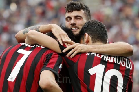 AC Milan's Nikola Kalinic, left, celebrates with his teammates Hakan Calhanoglu, right, and Patrick Cutrone after scoring his side's third goal during the Serie A soccer match between AC Milan and Fiorentina at the San Siro stadium in Milan, Italy, Sunday, May 20, 2018. (AP Photo/Antonio Calanni)