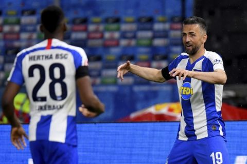 Hertha's Vedad Ibisevic, right, celebrates after scoring the opening goal during the German Bundesliga soccer match between Hertha BSC Berlin and 1. FC Union Berlin in Berlin, Germany, Friday, May 22, 2020. The German Bundesliga is the world's first major soccer league to resume after a two-month suspension because of the coronavirus pandemic. (Stuart Franklin/Pool Photo via AP)