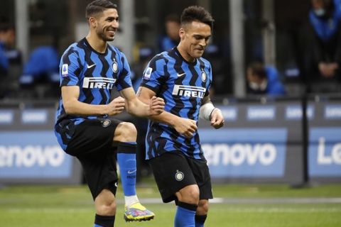 Inter Milan's Lautaro Martinez, right, celebrates with his teammate Achraf Hakimi after scores against Sassuolo during the Serie A soccer match between Inter Milan and Sassuolo at the San Siro Stadium in Milan, Italy, Wednesday, April 7, 2021. (AP Photo/Antonio Calanni)