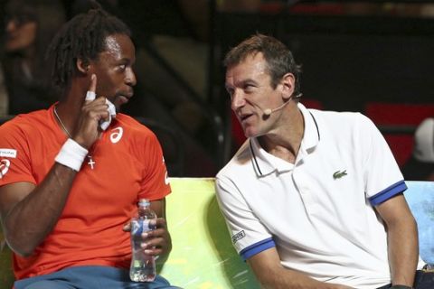 Gael Monfils of France, left, and Mats Wilander  chat on the bench during his match against Nick Kyrgios of Australia  during a Fast4 tennis tournament in Sydney, Australia, Monday, Jan. 11, 2016.(AP Photo/Rob Griffith)