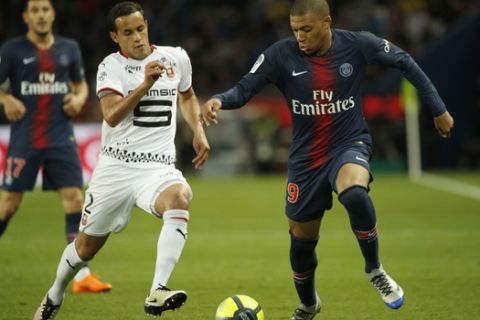 PSG's Kylian Mbappe, right, and Rennes' Mehdi Zeffane vie for the ball during their League One soccer match between Paris Saint-Germain and Stade Rennais at the Parc des Princes stadium in Paris, Saturday May 12, 2018. (AP Photo/Christophe Ena)