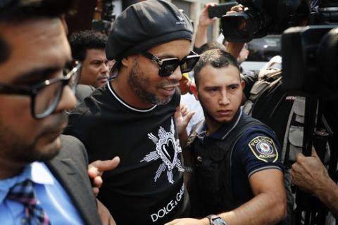 Former Brazilian soccer star Ronaldinho, whose full name is Ronaldo de Assis Moreira, center, leaves the attorney general's office in Asuncion, Paraguay, Thursday, March 5, 2020. Ronaldinho and his brother were detained by Paraguayan police for allegedly entering the country with falsified passports on Wednesday. (AP Photo/Jorge Saenz)