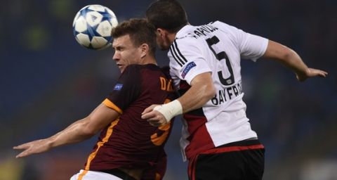 Roma's forward from Bosnia-Herzegovina Edin Dzeko (L) fights for the ball with Leverkusen's Greek defender Kyriakos Papadopoulos during the UEFA Champions League football match AS Roma vs Bayer Leverkusen on November 4, 2015 at the Olympic stadium in Rome.    AFP PHOTO / ANDREAS SOLARO        (Photo credit should read ANDREAS SOLARO/AFP/Getty Images)