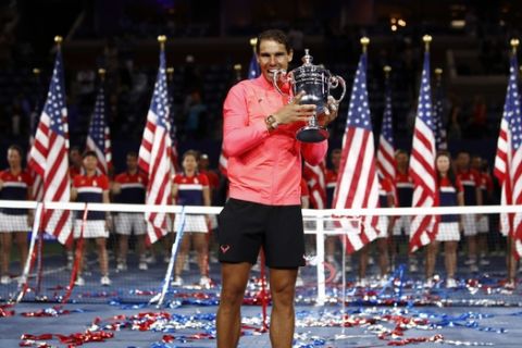 Rafael Nadal, of Spain, holds up the championship trophy after beating Kevin Anderson, of South Africa, in the men's singles final of the U.S. Open tennis tournament, Sunday, Sept. 10, 2017, in New York. (AP Photo/Julio Cortez)