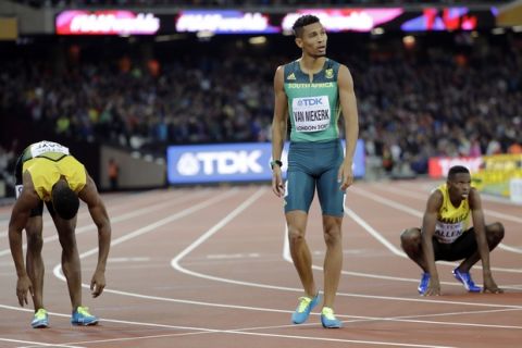 South Africa's Wayde Van Niekerk, center, stands in the finish after winning the gold medal in the Men's 400m final during the World Athletics Championships in London Tuesday, Aug. 8, 2017. (AP Photo/David J. Phillip)