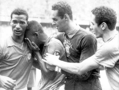 Brazil's Pele (second l) cries on the shoulder of Didi (l) as teammates Gilmar (second r) and Orlando (r) congratulate him on his fantastic performance in the final