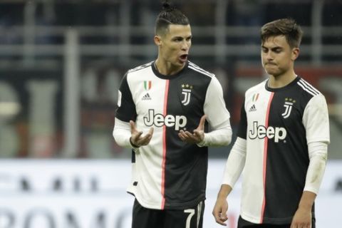 Juventus' Cristiano Ronaldo, left, speaks with Juventus' Paulo Dybala at the end of the Italian Cup soccer match between AC Milan and Juventus at the San Siro stadium, in Milan, Italy, Thursday, Feb. 13, 2020. (AP Photo/Luca Bruno)