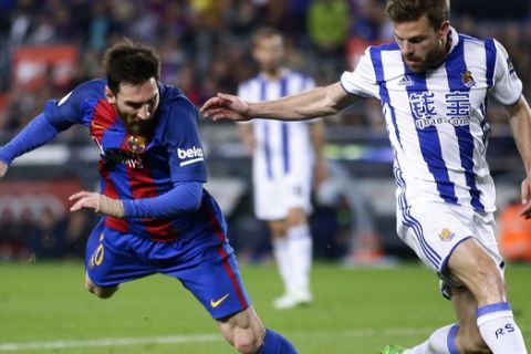 FC Barcelona's Lionel Messi, left, duels for the ball against Real Sociedad's Asier Illarramendi during the Spanish La Liga soccer match between FC Barcelona and Real Sociedad at the Camp Nou stadium in Barcelona, Spain, Saturday, April 15, 2017. (AP Photo/Manu Fernandez)