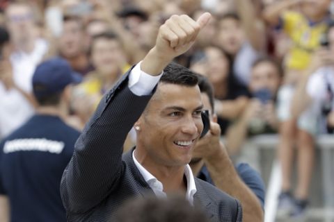 Portuguese ace Ronaldo salutes his fans as he arrives to undergo medical checks at the Juventus stadium in Turin, Italy, Monday, July 16, 2018. (AP Photo/Luca Bruno)