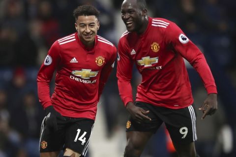 Manchester United's Jesse Lingard, left, celebrates scoring against West Bromwich Albion with teammate Romelu Lukakus during their English Premier League soccer match at The Hawthorns, West Bromwich, England, Sunday Dec. 17, 2017. (Nick Potts/PA via AP)