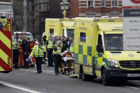 Emergency services staff provide medical attention close to the Houses of Parliament in London, Wednesday, March 22, 2017. London police say they are treating a gun and knife incident at Britain's Parliament "as a terrorist incident until we know otherwise." The Metropolitan Police says in a statement that the incident is ongoing. Officials say a man with a knife attacked a police officer at Parliament and was shot by officers. Nearby, witnesses say a vehicle struck several people on the Westminster Bridge.  (AP Photo/Matt Dunham)
