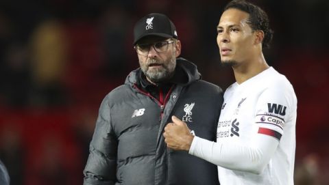 Liverpool's Virgil van Dijk, right and Liverpool's manager Jurgen Klopp greet supporters at the end of the English Premier League soccer match between Manchester United and Liverpool at the Old Trafford stadium in Manchester, England, Sunday, Oct. 20, 2019. (AP Photo/Jon Super)