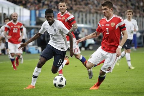 France's Ousmane Dembele, left, duels for the ball with Russia's Roman Neustadter during the international friendly soccer match between Russia and France at the Saint Petersburg stadium in St.Petersburg, Russia, Tuesday, March 27, 2018. (AP Photo/Dmitri Lovetsky)