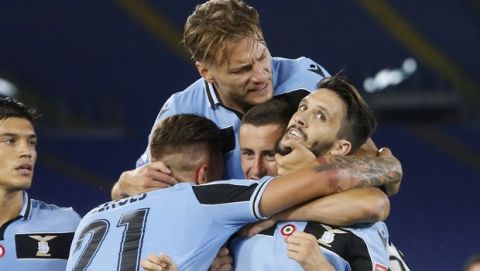 Lazio's Luis Alberto, right, celebrates with his teammates Sergej Milinkovic-Savic,Adam Marusic and Ciro Immobile, on top, after scoring his side's second goal during a Serie A soccer match between Lazio and Fiorentina at Rome's Olympic stadium, Saturday, June 27, 2020. (AP Photo/Riccardo de Luca)