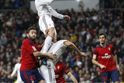 MADRID, SPAIN - JANUARY 09: Cristiano Ronaldo (Up) of Real Madrid jumps for the ball over Karim Benzema (R) and Damia Abella of Osasuna during the Copa del Rey round of 16 first leg match between Real Madrid and Osasuna at Estadio Santiago Bernabeu on January 9, 2014 in Madrid, Spain.  (Photo by Angel Martinez/Real Madrid via Getty Images)