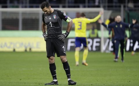 Italy goalkeeper Gianluigi Buffon reacts to his team's elimination as Sweden players celebrate, rear, celebrate at the end of the World Cup qualifying play-off second leg soccer match between Italy and Sweden, at the Milan San Siro stadium, Italy, Monday, Nov. 13, 2017. (AP Photo/Luca Bruno)