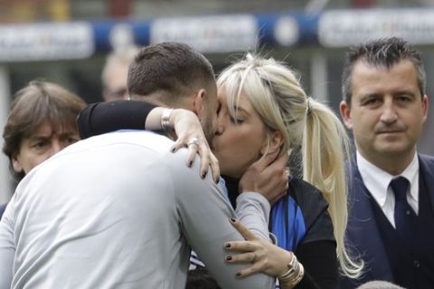 Inter Milan's Mauro Icardi kisses his wife Wanda Nara after receiving a prize for his 100 goal with the Inter Milan jersey, prior to the start of a Serie A soccer match between Inter Milan and Hellas Verona, at the San Siro stadium in Milan, Italy, Saturday, March 31, 2018. (AP Photo/Luca Bruno)