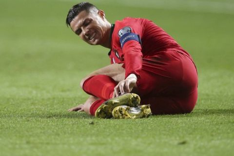 Portugal's Cristiano Ronaldo lies in the pitch during the Euro 2020 group B qualifying soccer match between Portugal and Ukraine at the Luz stadium in Lisbon, Friday, March 22, 2019. (AP Photo/Armando Franca)