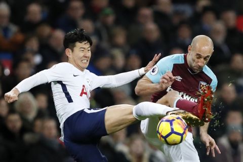 Tottenham's Son Heung-min, left, fights for the ball with West Ham's Pablo Zabaleta during the English Premier League soccer match between Tottenham Hotspur and West Ham United at Wembley Stadium in London, Thursday, Jan. 4, 2018. (AP Photo/Kirsty Wigglesworth)
