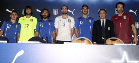 From left, players Marco Verratti, Mattia Perin, Andrea Pirlo, Giorgio Chiellini, Davide Astori, coach Cesare Prandelli and Gianluigi Buffon pose during a press conference for the presentation of the new Italy soccer team jersey, in Milan, Italy, Monday, March 3, 2014.  Mario Balotelli is out injured and Daniele De Rossi has been dropped due to a code of ethics violation for Italy's friendly at World Cup holder Spain on Wednesday. Missing two key starters, coach Cesare Prandelli gave Torino forward Ciro Immobile and Parma defender Gabriel Paletta their first call ups to Italy's squad on Sunday. (AP Photo/Antonio Calanni)