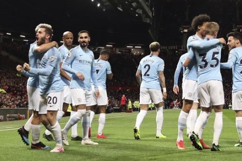 Manchester City's Bernardo Silva, left, celebrates after scoring the opening goal during the English Premier League soccer match between Manchester United and Manchester City at Old Trafford Stadium in Manchester, England, Wednesday April 24, 2019. (AP Photo/Jon Super)