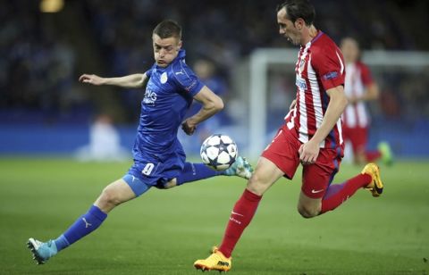 Leicester City's Jamie Vardy and Atletico Madrid's Diego Godin, right, challenge for the ball during the second leg of the UEFA Champions League quarter final soccer match at the King Power Stadium in Leicester, Tuesday April 18, 2017. (Nick Potts/PA via AP)