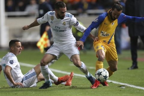 Real Madrid's Daniel Carvajal, center, and his teammate Lucas Vazquez, left, try to stop APOEL's Efstathios Aloneftis during the Champions League Group H soccer match between APOEL Nicosia and Real Madrid at GSP stadium, in Nicosia, on Tuesday, Nov. 21, 2017. (AP Photo/Petros Karadjias)